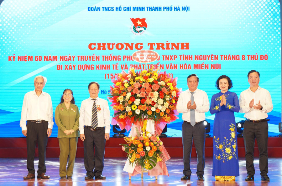 Phó Bí thư Thành ủy Hà Nội Nguyễn Văn Phong tặng hoa chúc mừng cựu Thanh niên xung phong tình nguyện Tháng 8 Thủ đô. Ảnh: Thủy Tiên