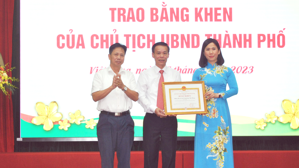 B&iacute; thư Đảng ủy phường Đinh&nbsp; Quang Luận (giữa) v&agrave; Chủ tịch UBND phường Việt Hưng Đặng Th&uacute;y V&acirc;n (&aacute;o d&agrave;i) thay mặt Nh&acirc;n d&acirc;n v&agrave; c&aacute;n bộ phường phường Việt Hưng đ&oacute;n nhận Bằng khen của Chủ tịch UBND TP H&agrave; Nội v&igrave; những th&agrave;nh t&iacute;ch trong phong tr&agrave;o To&agrave;n d&acirc;n bảo vệ An ninh Tổ quốc.