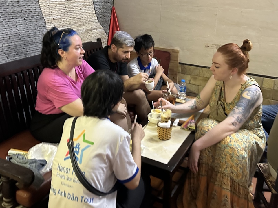 Hướng dẫn viên cùng du khách thưởng thức món cafe trứng của Việt Nam. Ảnh: Thảo Nguyên