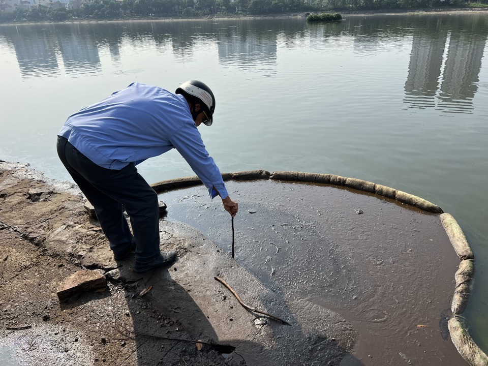 Lực lượng chức năng thu gom, xử lý dầu thải tồn đọng tại các hồ trên địa bàn thành phố. Ảnh: Công Trình