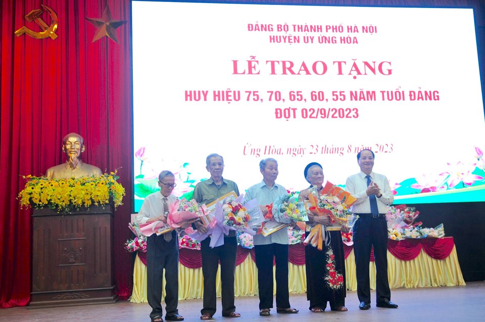 Uỷ vi&ecirc;n Ban Thường vụ Th&agrave;nh uỷ, Trưởng ban Tuy&ecirc;n gi&aacute;o Th&agrave;nh uỷ H&agrave; Nội Nguyễn Do&atilde;n Toản trao Huy hiệu Đảng cho c&aacute;c Đảng vi&ecirc;n. Ảnh: Lại Tấn.