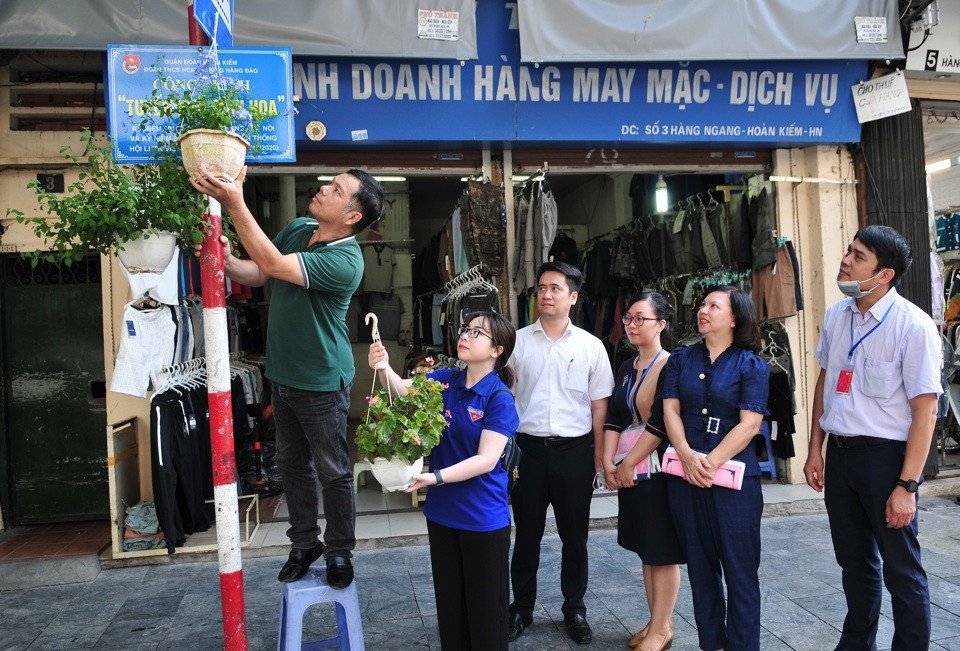 Cột đ&egrave;n, bảng t&ecirc;n đường tại phường H&agrave;ng Đ&agrave;o được trang ho&agrave;ng bằng những chậu hoa tươi rực rỡ sắc m&agrave;u.