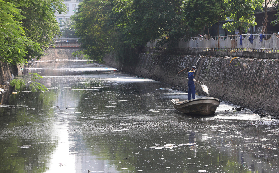Nhân viên môi trường vớt rác trên mặt sông Sét. Ảnh: Ngọc Thành