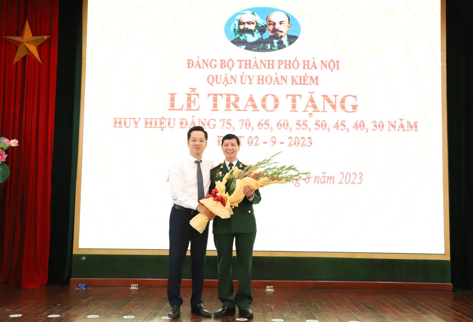 B&iacute; thư Quận ủy Ho&agrave;n Kiếm Vũ Đăng Định tặng hoa ch&uacute;c mừng c&aacute;c đảng vi&ecirc;n của Đảng bộ quận Ho&agrave;n Kiếm&nbsp;được trao Huy hiệu Đảng đợt 2/9 năm nay