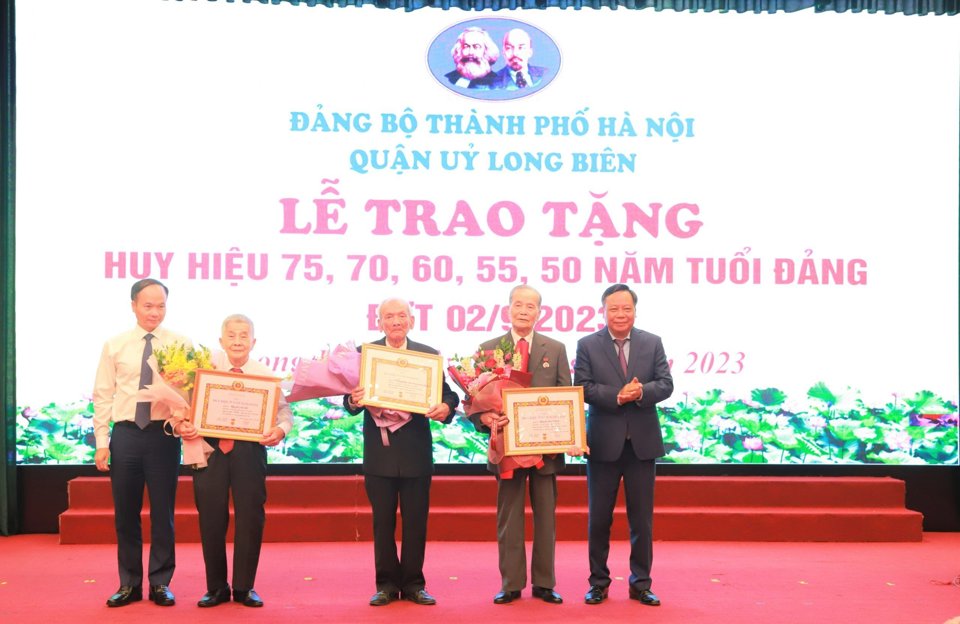 Phó Bí thư Thành ủy Nguyễn Văn Phong và Bí thư Quận ủy Long Biên Đường Hoài Nam trao Huy hiệu 75 năm, 70 năm tuổi Đảng cho các đảng viên lão thành. Ảnh: Trần Long