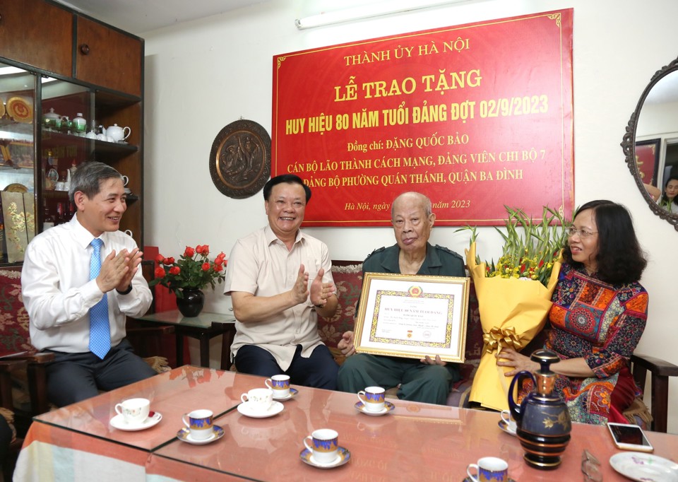 B&iacute; thư Th&agrave;nh ủy Đinh Tiến Dũng trao Huy hiệu 80 năm tuổi Đảng cho Thiếu tướng Đặng Quốc Bảo.