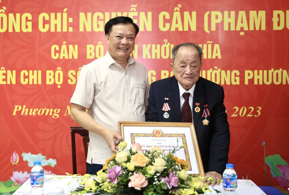 B&iacute; thư Th&agrave;nh ủy Đinh Tiến Dũng trao Huy hiệu 80 năm tuổi Đảng cho đảng vi&ecirc;n&nbsp;Nguyễn Cần.