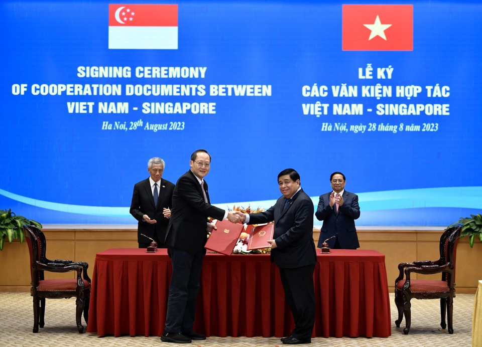 Bộ trưởng Bộ KH&ĐT Nguyễn Chí Dũng (phải) và Bộ trưởng Bộ Nhân lực kiêm Bộ trưởng thứ hai Bộ Công Thương Singapore Tan See Leng (trái) ký Công thư. Ảnh: Hải Nguyễn