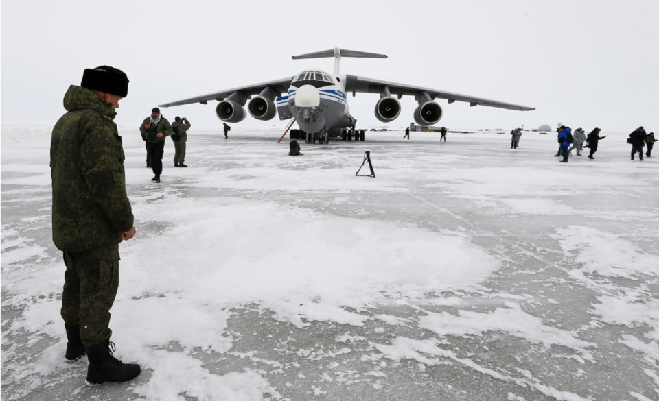 Một sĩ quan Nga đứng gần m&aacute;y bay chở h&agrave;ng qu&acirc;n sự Il-76 tr&ecirc;n đảo Alexandra Land gần Nagurskoye, Nga v&agrave;o th&aacute;ng 5/2021. Ảnh: AP