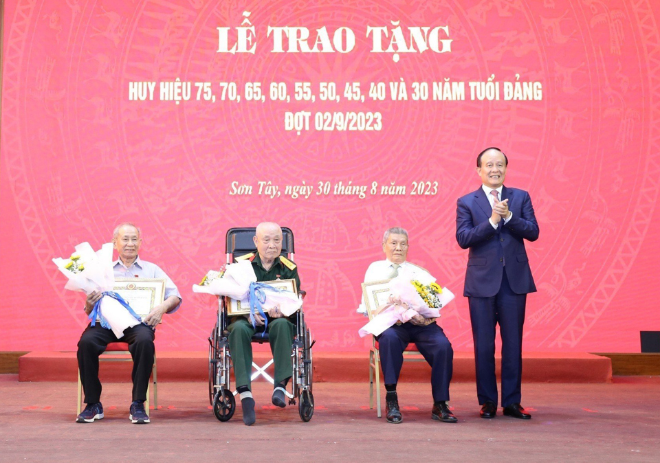 Chủ tịch HĐNDTP Hà Nội Nguyễn Ngọc Tuấn trao Huy hiệu Đảng cho các đảng viên lão thành. Ảnh: Vân Hà