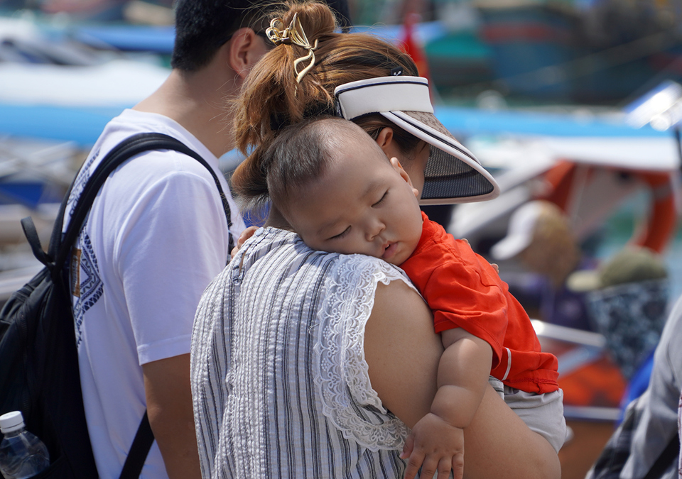 Một em b&eacute; ngủ v&ugrave;i tr&ecirc;n vai mẹ trước khi l&ecirc;n t&agrave;u tham quan vịnh Nha Trang.
