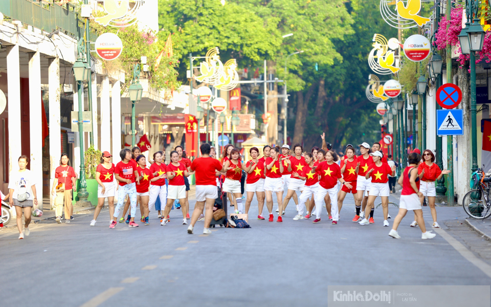 Khu vực phố Trang Tiền, người d&acirc;n mặc trang phục cờ đỏ sao v&agrave;ng tham gia c&aacute;c hoạt động vui chơi tập thể.