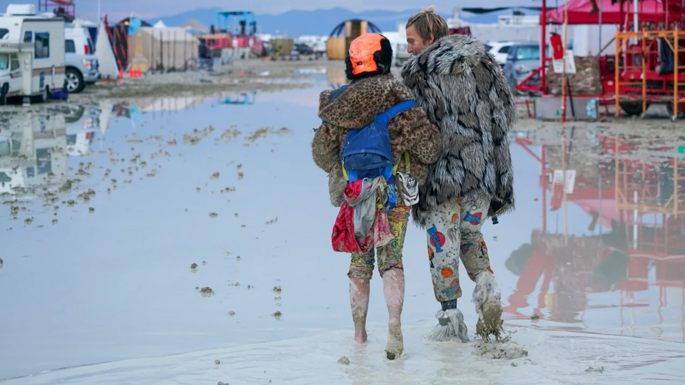 Những người tham dự Burning Man đi bộ qua b&ugrave;n v&agrave;o thứ Bảy. Nguồn: CNN