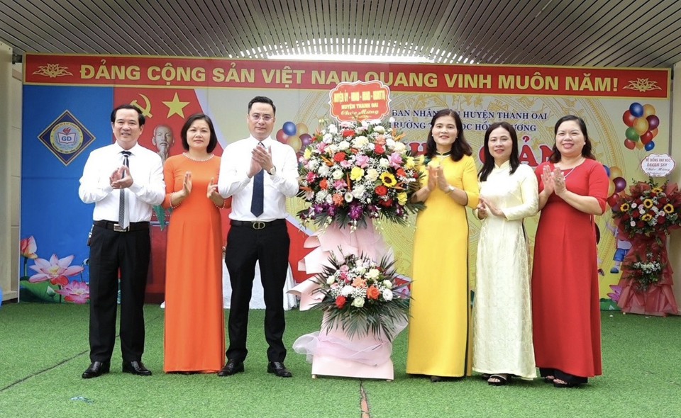 Chủ tịch UBND huyện Thanh Oai B&ugrave;i Văn S&aacute;ng tặng hoa ch&uacute;c mừng c&ocirc; v&agrave; tr&ograve; trường Tiểu học Hồng Dương