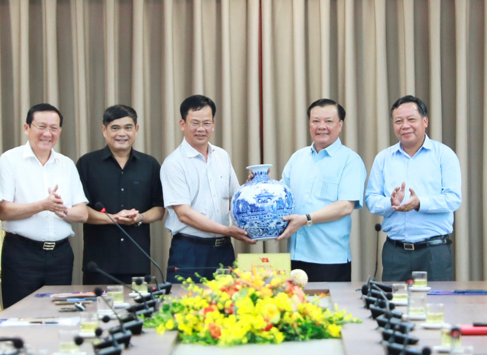 Bí thư Thành ủy Hà Nội Đinh Tiến Dũng tặng quà lưu niệm cho lãnh đạo huyện Lâm Hà (tỉnh Lâm Đồng). Ảnh: Quang Thái