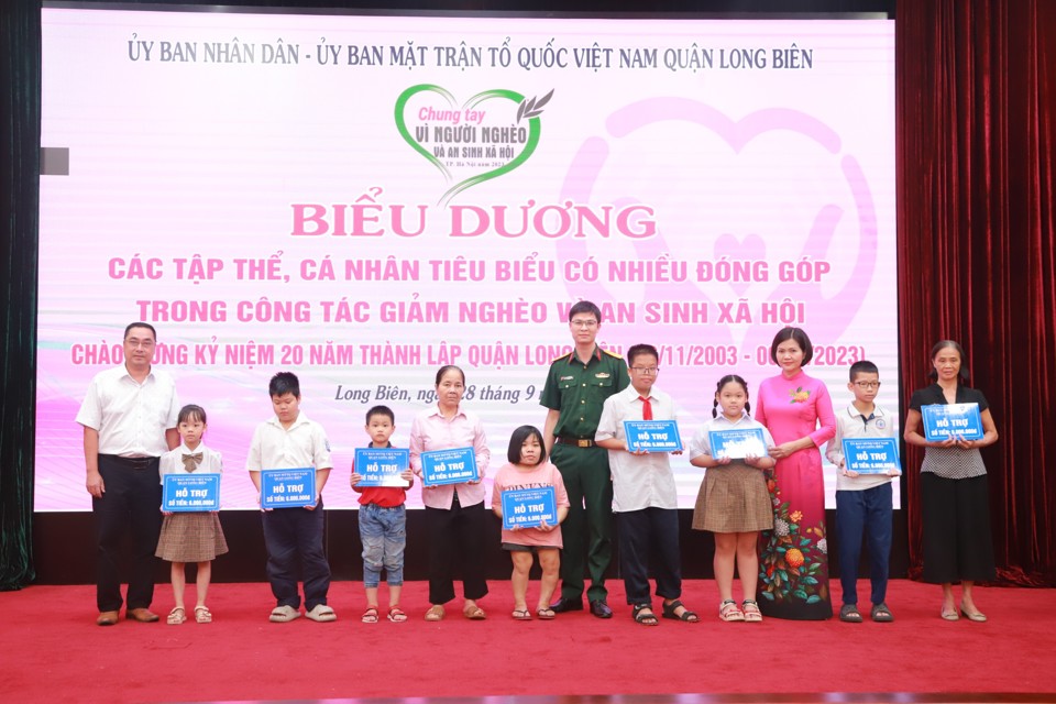 Ph&oacute; Chủ tịch UBND quận Long Bi&ecirc;n Đinh Thị Thu Hương (thứ ba từ phải qua) v&agrave; c&aacute;c nh&agrave; t&agrave;i trợ trao tiền hỗ trợ những trường hợp diện ch&iacute;nh s&aacute;ch tr&ecirc;n địa b&agrave;n quận.