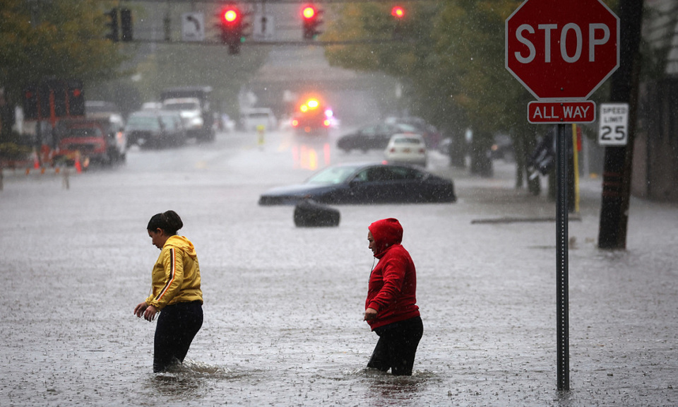 Chiếc xe bị thả tr&ocirc;i v&agrave; người d&acirc;n cố gắng đi qua tuyến đường bị ngập sau trận mưa lớn tại thị trấn Mamaroneck, hạt Westchester, bang New York. Ảnh: Reuters &nbsp;
