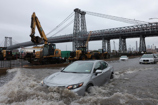Phương tiện di chuyển tr&ecirc;n một con đường bị ngập gần cầu Williamsburg ở khu Manhattan. Ảnh: Reuters &nbsp; &nbsp;