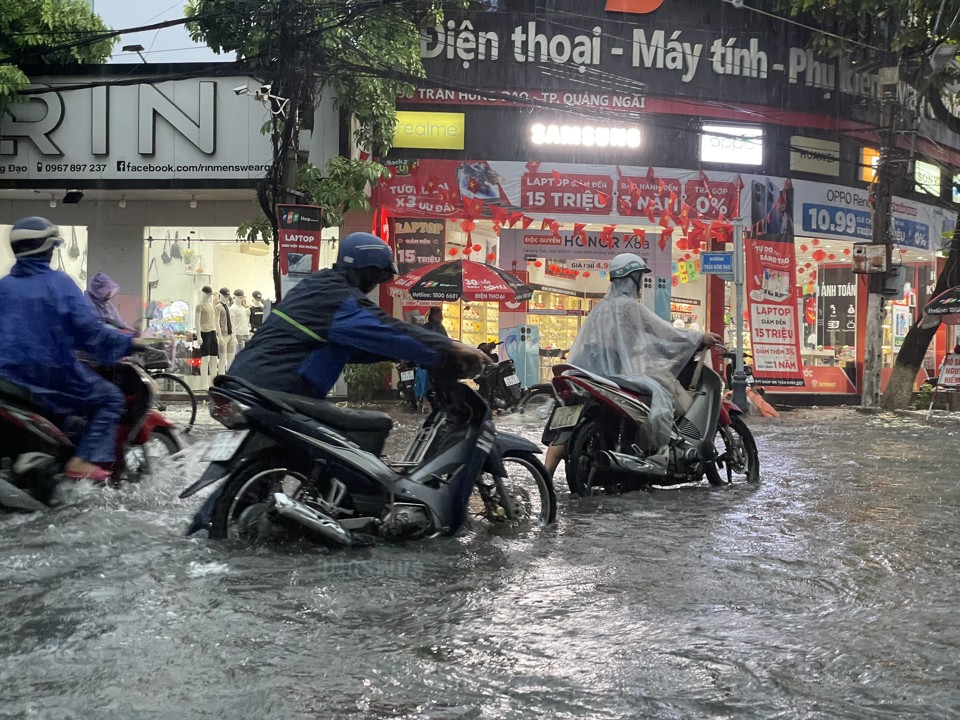 Người d&acirc;n&nbsp;dắt bộ tr&ecirc;n đường Trần Hưng Đạo sau trận mưa lớn chiều ng&agrave;y 29/8.