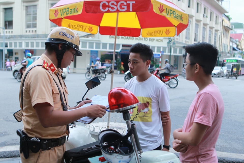 Cảnh sát giao thông lập biên bản đối với lái xe vi phạm trên phố Tràng Thi, quận Hoàn Kiếm. Ảnh: Phạm Hùng