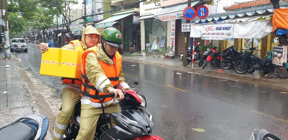 C&ocirc;ng an phường Ch&iacute;nh Gi&aacute;n hỗ trợ mang thực phẩm cho người d&acirc;n v&ugrave;ng ngập s&acirc;u.