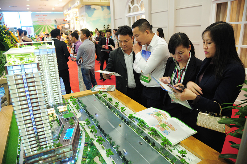 Nhân viên kinh doanh bất động sản giới thiệu đến khách hàng một dự án nhà ở tại Hà Nội. Ảnh: Phạm Hùng