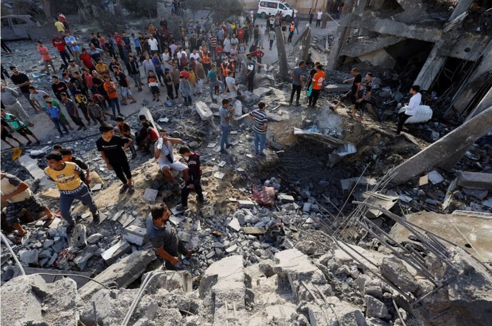 Người d&acirc;n t&igrave;m kiếm người bị thương dưới đống đổ n&aacute;t của một t&ograve;a nh&agrave; bị ph&aacute; hủy bởi c&aacute;c cuộc tấn c&ocirc;ng của Israel ở Khan Younis, ph&iacute;a nam Dải Gaza. Ảnh: Reuters