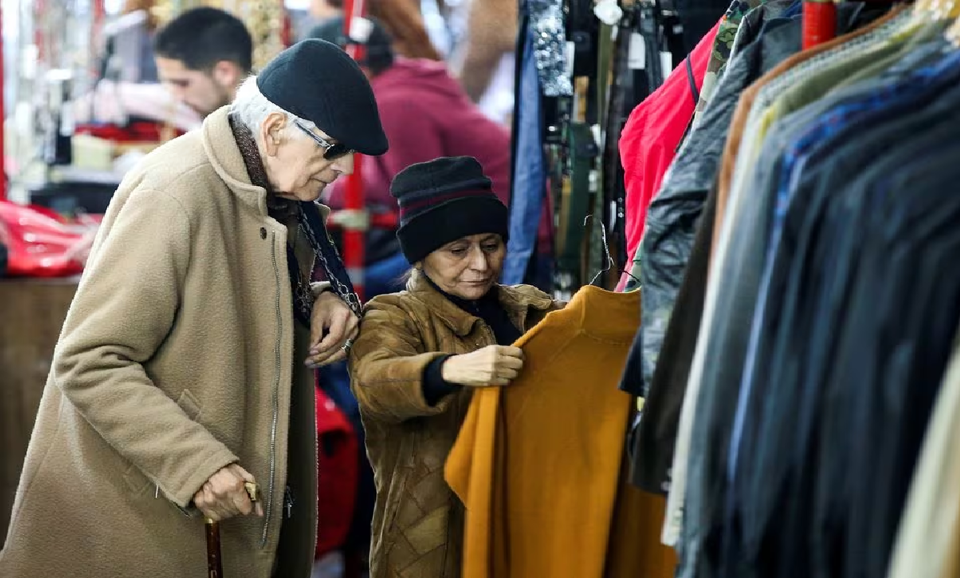 Người d&acirc;n phải mua quần &aacute;o cũ tại hội chợ. Ảnh: Reuters