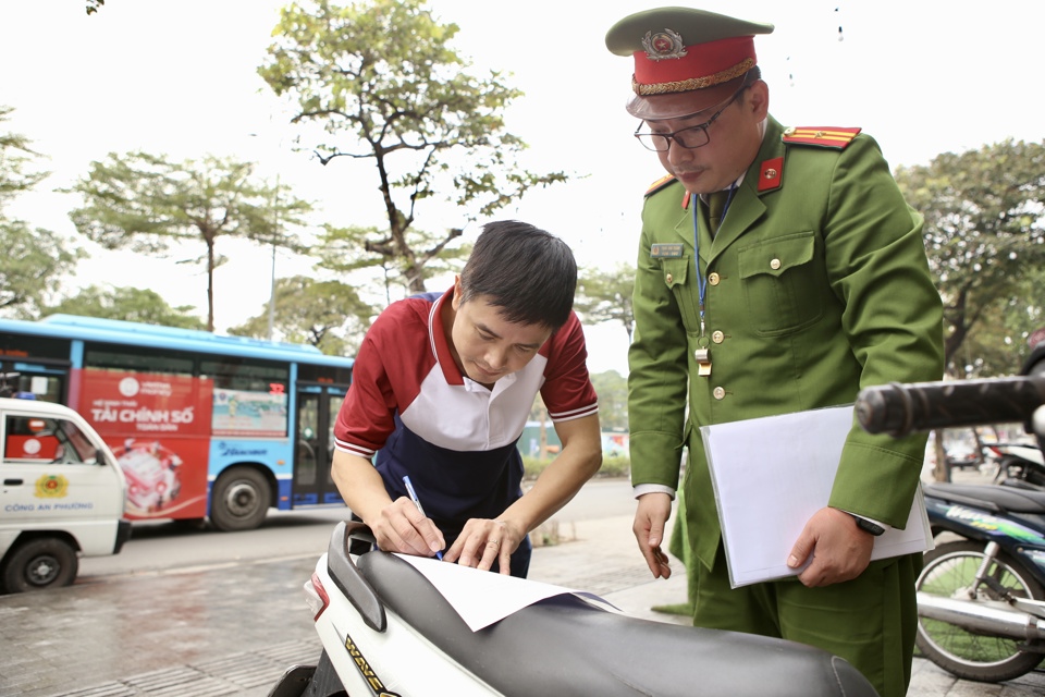 Lực lượng chức năng tuy&ecirc;n truyền, nhắc nhở hộ kinh doanh k&yacute; cam kết kh&ocirc;ng lấn chiếm l&ograve;ng đường vỉa h&egrave;.