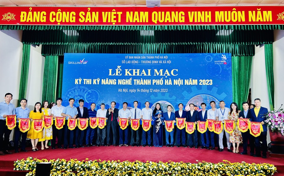 Ph&oacute; Tổng cục trưởng Tổng cục Gi&aacute;o dục nghề nghiệp Đỗ Năng Kh&aacute;nh, Gi&aacute;m đốc Sở LĐTB&amp;XH H&agrave; Nội Bạch Li&ecirc;n Hương trao cờ lưu niệm cho c&aacute;c đơn vị tham dự Kỳ thi Kỹ năng nghề TP H&agrave; Nội năm 2023. Ảnh: Trần Oanh.