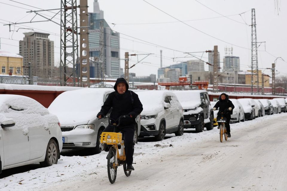 Người d&acirc;n đạp xe tr&ecirc;n con đường phủ đầy tuyết sau trận tuyết rơi ở Bắc Kinh v&agrave;o ng&agrave;y 15/12. Ảnh: Reuters