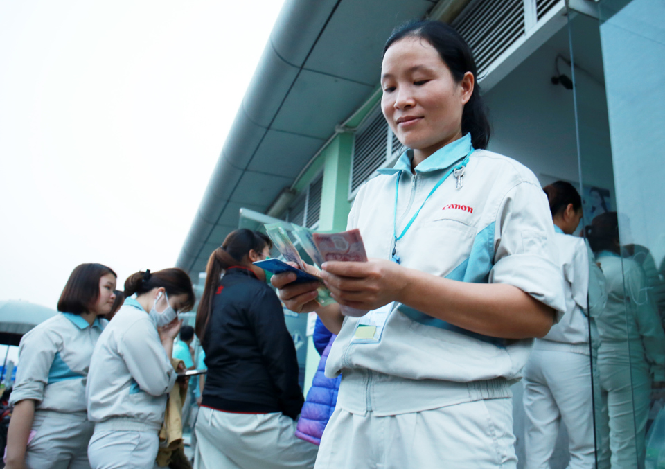 Tăng lương tối thiểu v&ugrave;ng sẽ gi&uacute;p người lao động c&oacute; th&ecirc;m thu nhập, cải thiện cuộc sống. Trong ảnh. C&ocirc;ng nh&acirc;n khu c&ocirc;ng nghiệp r&uacute;t tiền lương tại c&acirc;y ATM. Ảnh Phạm H&ugrave;ng