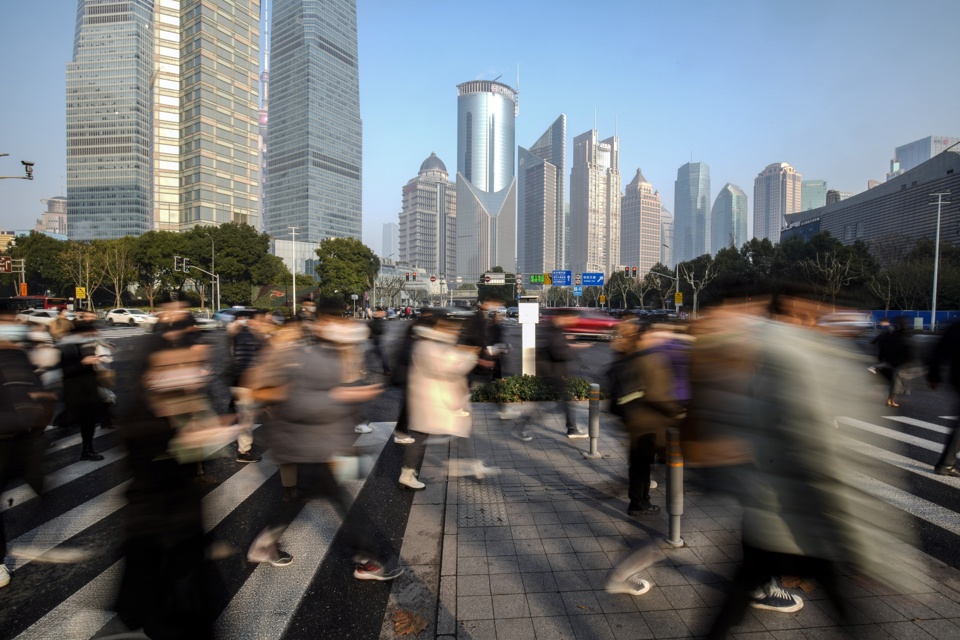 Người đi bộ băng qua đường ở Khu t&agrave;i ch&iacute;nh Lujiazui của Pudong ở Thượng Hải, Trung Quốc. Ảnh: Bloomberg