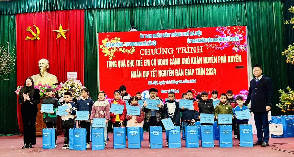 Gi&aacute;m đốc Sở LĐTB&amp;XH H&agrave; Nội Bạch Li&ecirc;n Hương, B&iacute; thư Huyện ủy Ph&uacute; Xuy&ecirc;n Nguyễn Xu&acirc;n Thanh tặng qu&agrave; cho trẻ em c&oacute; ho&agrave;n cảnh kh&oacute; khăn. Ảnh: Trần Oanh.