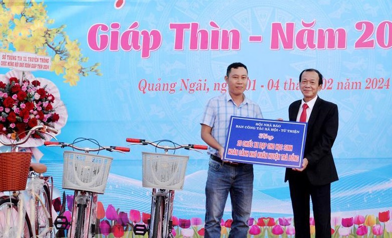 Hội Nh&agrave; b&aacute;o tỉnh Quảng Ng&atilde;i trao bảng tượng trưng tặng 20 chiếc xe đạp.