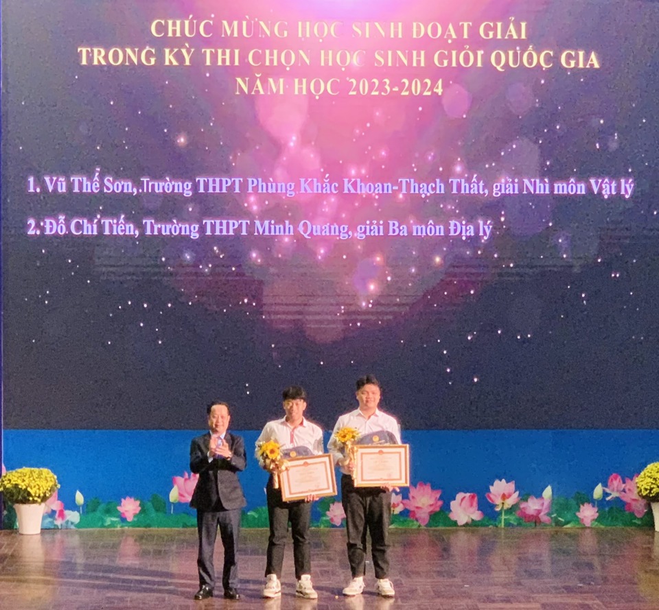 Giám đốc Sở GD&ĐT Hà Nội Trần Thế Cương trao thưởng cho hai học sinh Vũ Thế Sơn và Đỗ Chí Tiến