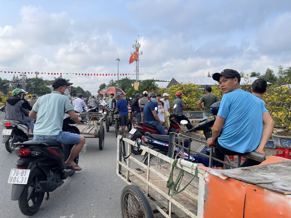 Những người l&agrave;m dịch vụ chở hoa mỏi m&ograve;n chờ kh&aacute;ch.&nbsp;Ảnh: H&agrave; Phương