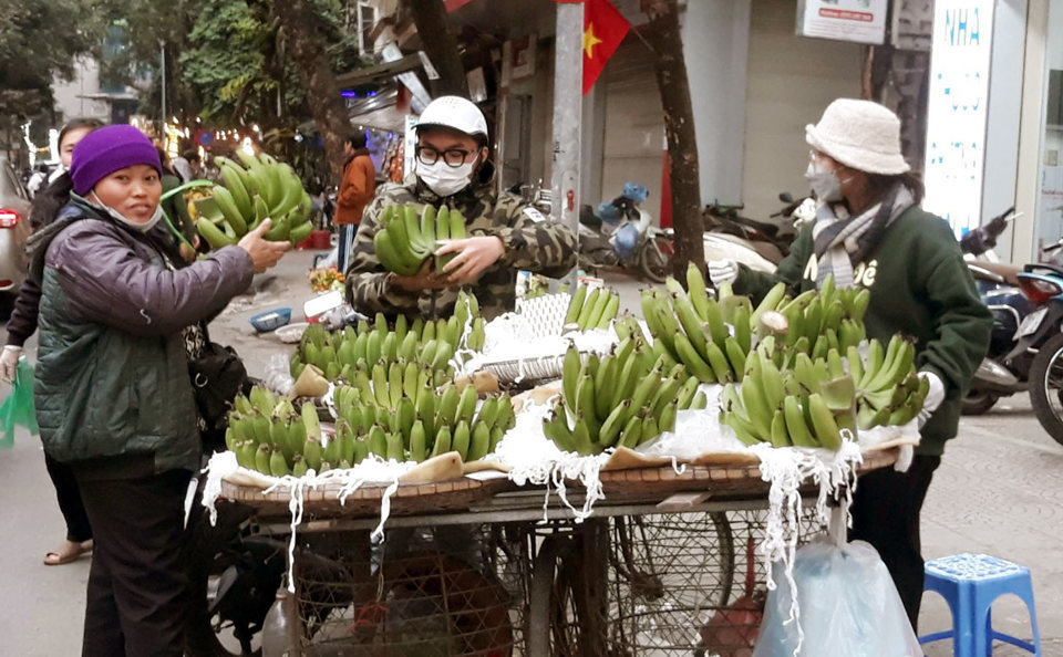 Người ti&ecirc;u d&ugrave;ng mua chuối xanh tại chợ G&ograve; Đống Đa ng&agrave;y 29 Tết. Ảnh: Ho&agrave;i Nam