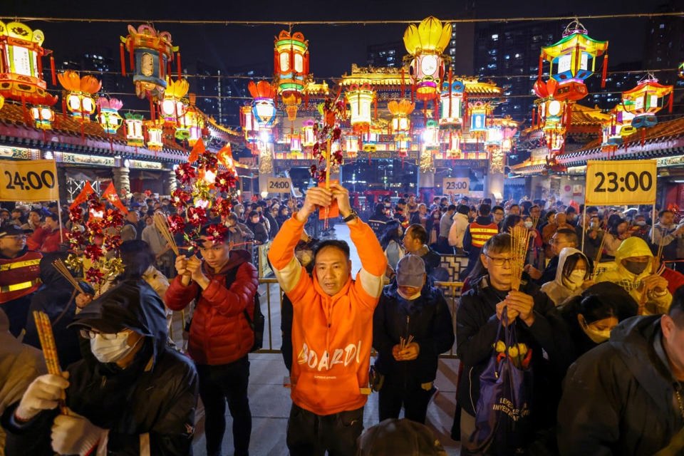 Những người thờ c&uacute;ng d&acirc;ng hương đầu ti&ecirc;n tại ch&ugrave;a Wong Tai Sin, Hong Kong v&agrave;o đ&ecirc;m giao thừa &acirc;m lịch, như một phần của lễ hội ch&agrave;o đ&oacute;n năm con Rồng. Ảnh: SCMP