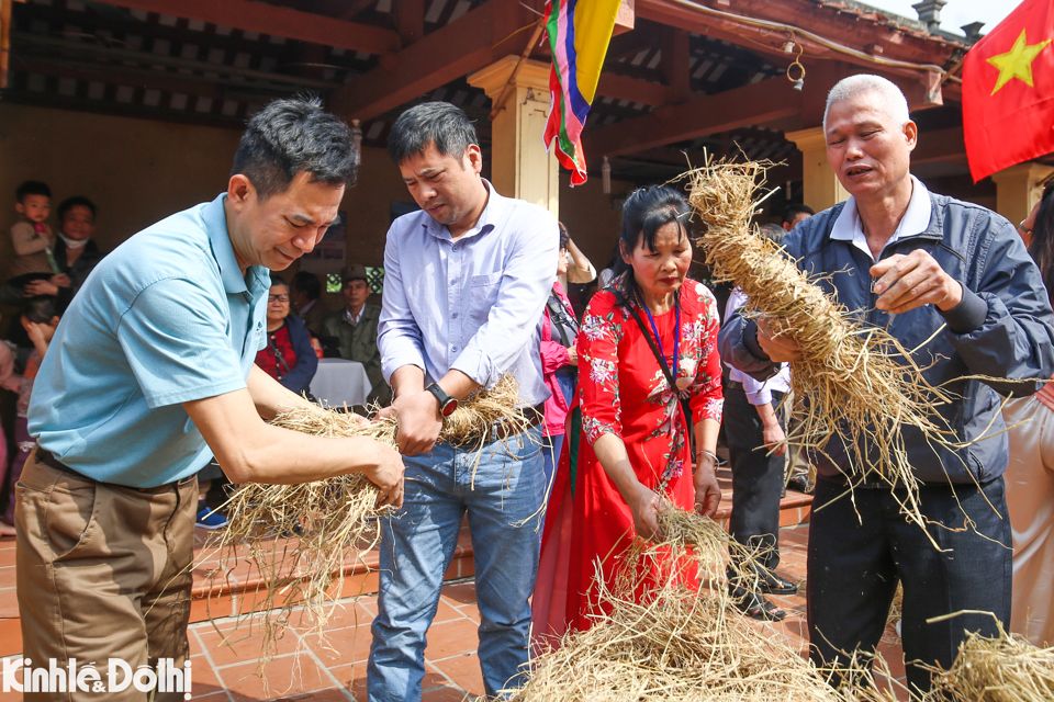 Người chơi c&ugrave;ng d&acirc;n l&agrave;ng bện rơm để l&oacute;t cối khi gi&atilde; gạo.