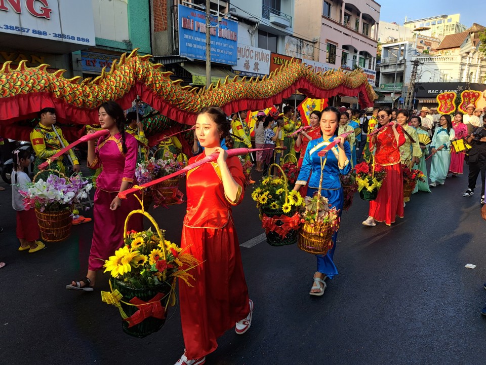 Thiếu nữ g&aacute;nh hoa thuộc Hội La Cổ Sư Tr&uacute;c Hi&ecirc;n diễu h&agrave;nh Tết Nguy&ecirc;n ti&ecirc;u. Ảnh: T&acirc;n Tiến.