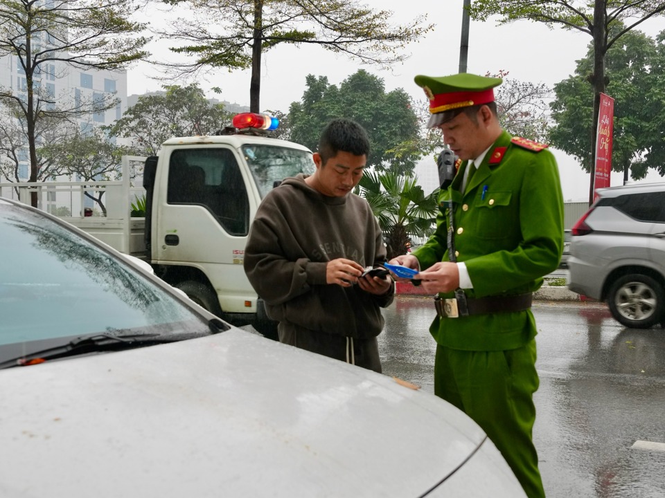 Lực lượng chức năng kiểm tra, xử l&yacute; một trường hợp d&ugrave;ng đỗ phương tiện sai quy định tại cổng Bệnh viện Huyết học.