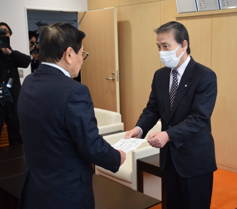 &Ocirc;ng Hideo Kojima (phải) trao đơn từ chức cho người đứng đầu hội đồng thị trấn Ginan tại t&ograve;a thị ch&iacute;nh. Ảnh:&nbsp;Japantimes
