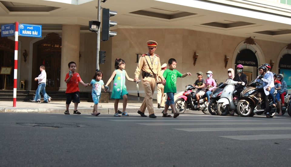 Cảnh sát giao thông Hà Nội giúp đỡ trẻ em qua đường. Ảnh: Công Hùng