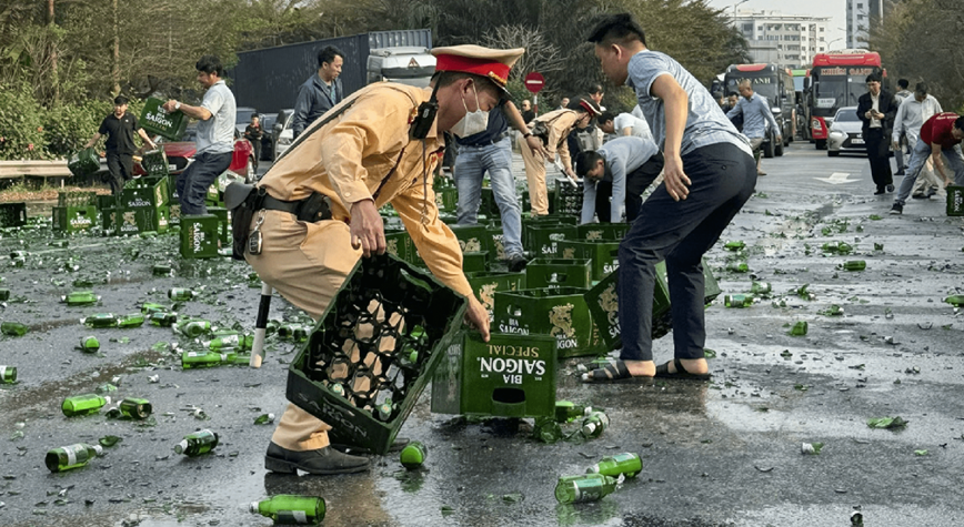 Cảnh sát giao thông cùng người dân thu dọn hàng trăm thùng bia rơi xuống đường - Ảnh 1