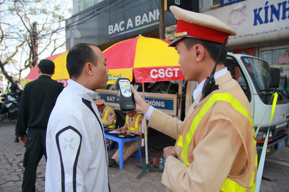 Cảnh sát giao thông kiểm tra nồng độ cồn lái xe trên đường Lạc Long Quân, Tây Hồ, Hà Nội. Ảnh: Phạm Hùng