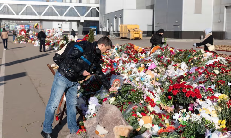 Một người đ&agrave;n &ocirc;ng đặt hoa cho c&aacute;c nạn nh&acirc;n của vụ tấn c&ocirc;ng tại t&ograve;a thị ch&iacute;nh Crocus, Moscow, ng&agrave;y 28/3. Ảnh: Shutterstock