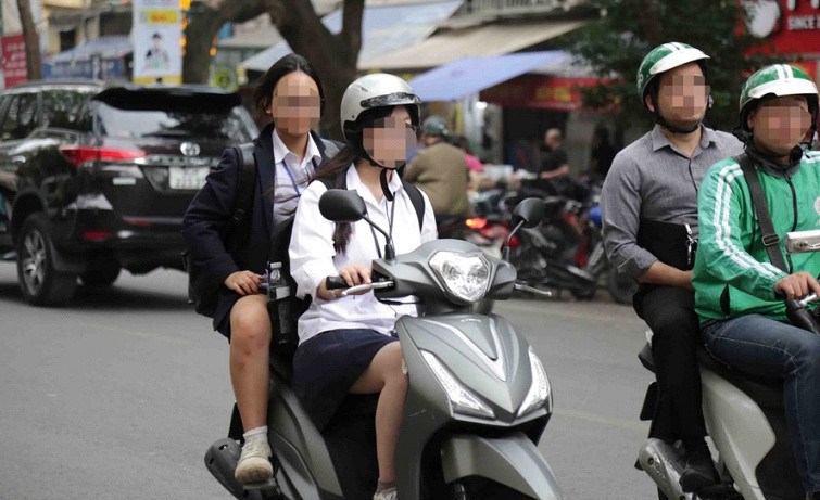 Một trường hợp học sinh điều khiển xe m&aacute;y ph&iacute;a sau chở theo người kh&ocirc;ng đội mũ bảo hiểm. Ảnh: Trần Thanh.