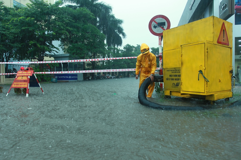 Công nhân thoát nước Hà Nội làm nhiệm vụ tại một điểm ngập úng trong đợt mưa bão. Ảnh: Phạm Hùng