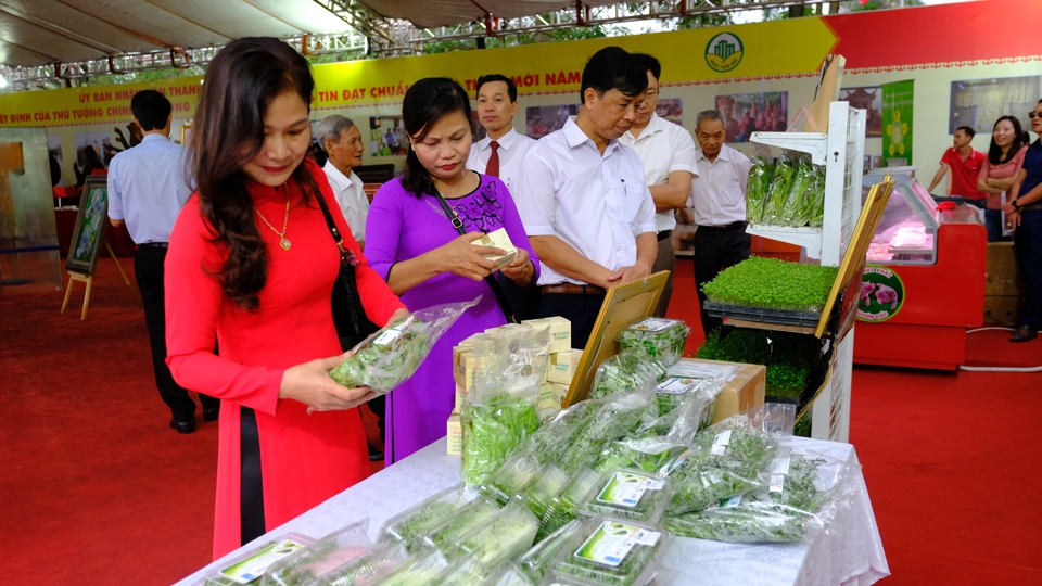 Khách hàng tìm hiểu thông tin hàng hóa tại Hội chợ giao thương nông sản diễn ra trên địa bàn huyện Đông Anh, Hà Nội.  Ảnh: Phạm Hùng